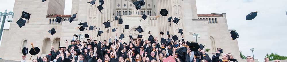 Students tossing caps in the air in front of cathedral